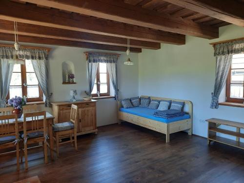 a bedroom with a blue bed and a table at Chaloupka Pomněnka na Lipce in Nasavrky