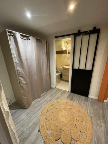 La salle de bains est pourvue d'une douche et d'une porte avec un tapis. dans l'établissement L’Ecrin de Lolo, à Albi
