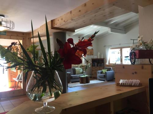 a vase of flowers on a table in a living room at Fedaia Joy B&B in Canazei