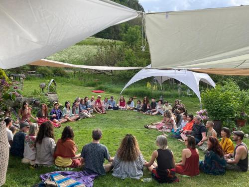 a group of people sitting in the grass under a tent at Domaine Bellevie BnB in Vex