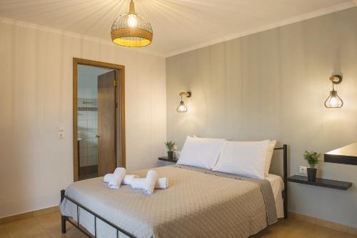un dormitorio con una cama con dos animales de peluche en Garbis Garden View, en Valsamáta
