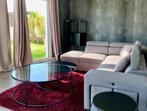 a living room with a couch and a glass table at Bella Vista Hôtel, Suites & Maisons in Porticcio