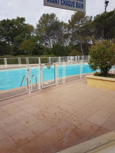 - une vue sur la piscine avec des bars blancs dans l'établissement Charmant studio dans la résidence Haut du Golf, à Valescure