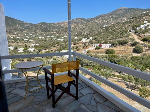 a chair and table on a balcony with a view at Venikouas Hotel in Platis Yialos Sifnos