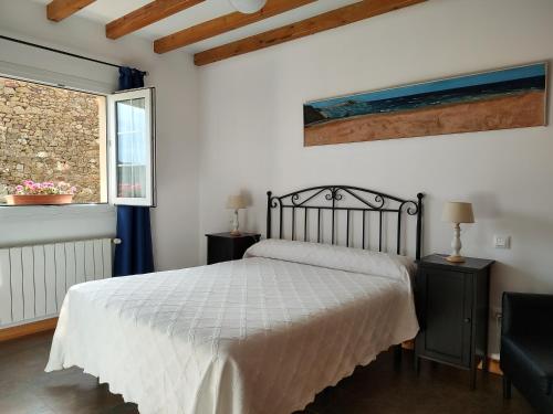 a bedroom with a white bed and a window at Apartamentos Corona in Comillas