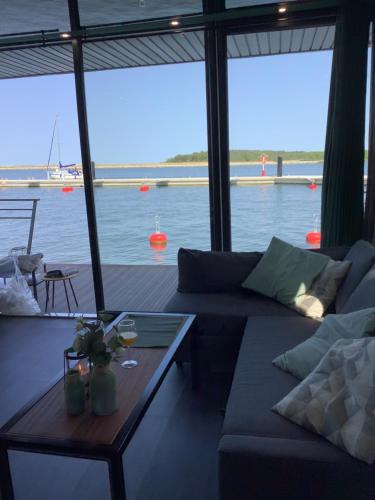 un soggiorno con divano e vista sull'acqua di Domy Na Wodzie 3Miasto a Danzica
