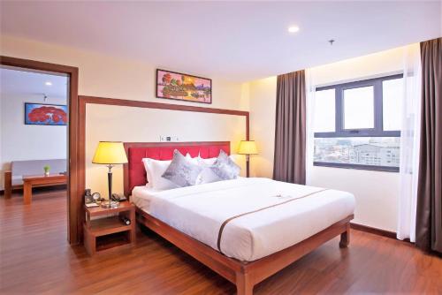 a bedroom with a large bed with a red headboard at Poulo Wai Hotel & Apartment in Phnom Penh