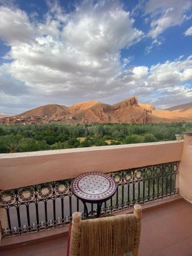 una mesa en un balcón con vistas a las montañas en Maison La Vallée Des Figues Dadès en Tamellalt