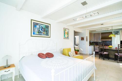 ein weißes Schlafzimmer mit einem weißen Bett und ein Wohnzimmer in der Unterkunft Beach House Sveti Jakov 2 in Dubrovnik