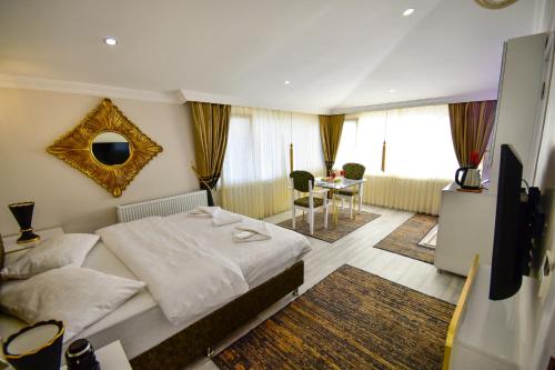 Schlafzimmer mit einem Bett, einem TV und einem Tisch in der Unterkunft Loca Suit in Istanbul
