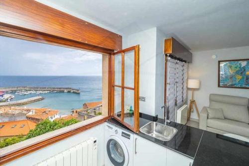 a kitchen with a sink and a window with a view at Mirador Del Puerto in Lastres