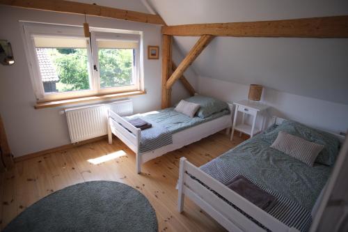 a attic room with two beds and a window at Siedlisko Orzechówko in Orzechówko