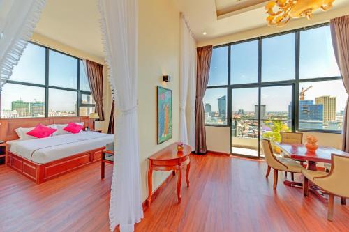 a bedroom with a bed and a table and chairs at Poulo Wai Hotel & Apartment in Phnom Penh