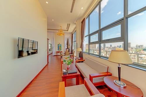 a living room with a couch and chairs and windows at Poulo Wai Hotel & Apartment in Phnom Penh