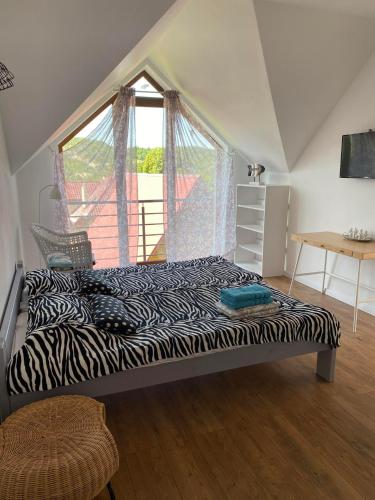 a bedroom with a zebra print bed in front of a window at Solina Bieszczady Noclegi in Solina