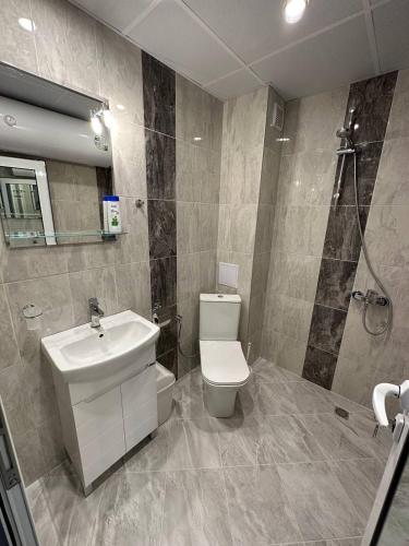 a bathroom with a toilet and a sink and a shower at Studios and Apartments Pomorie in Pomorie