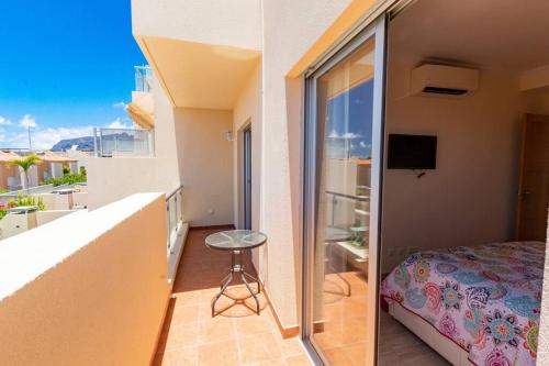 Cette chambre dispose d'un balcon avec un lit et une fenêtre. dans l'établissement Holiday Home with Private Pool by Dream Homes Tenerife, à Puerto de Santiago