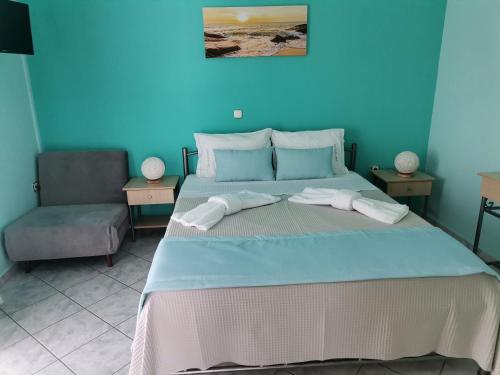 a blue bedroom with a bed and a chair at LASKARINA'S HOUSE in Skala Potamias