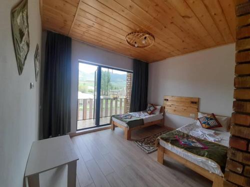 a living room with a couch and a large window at Guest House Jekshen in Imeni Karla Marksa