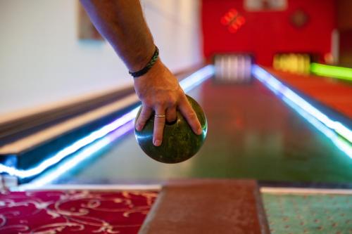 a person holding a cue ball in front of a bowling alley at Sattelbogener Hof in Traitsching