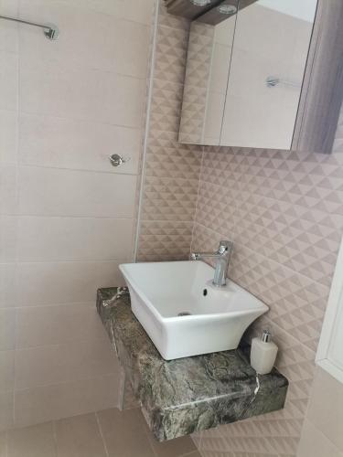 a bathroom with a white sink on a stone counter at LASKARINA'S HOUSE in Skala Potamias