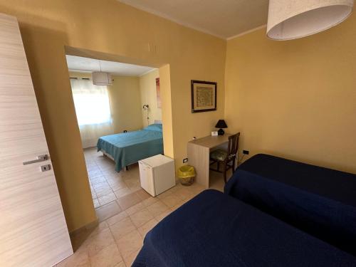 a bedroom with two beds and a table and a window at Baia dei turchi locazione turistica in Realmonte