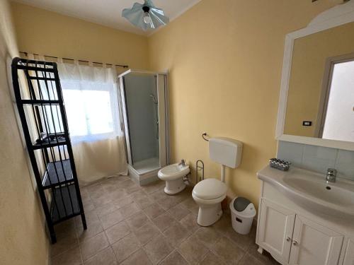 uma casa de banho com um WC, um chuveiro e um lavatório. em Baia dei turchi locazione turistica em Realmonte