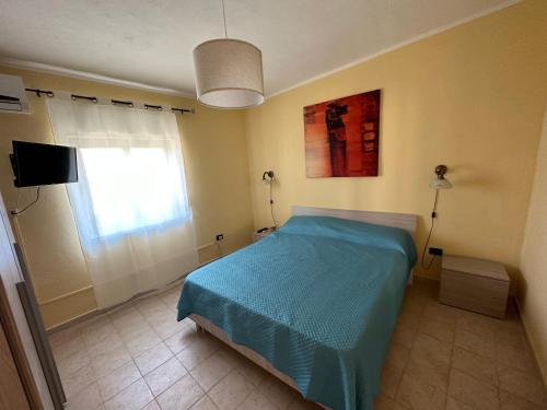 a bedroom with a blue bed and a window at Baia dei turchi locazione turistica in Realmonte