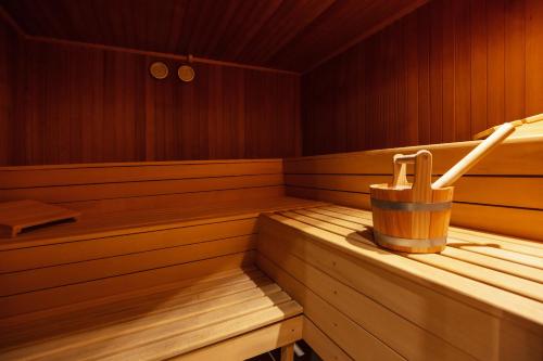 a wooden sauna with a wooden bucket and a wooden paddler at Sattelbogener Hof in Traitsching