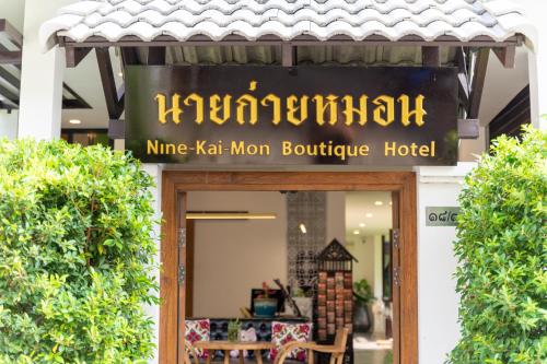 um sinal para um hotel boutique de esquerda em นายก่ายหมอน Nine-Kai-Mon em Chiang Mai