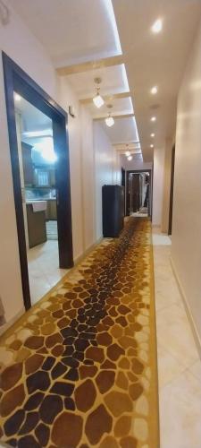 um corredor com um longo corredor com um piso coberto de rochas em شقة فيو نيلي no Cairo