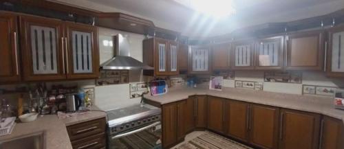 uma cozinha com armários de madeira e um forno com placa de fogão em شقة فيو نيلي no Cairo