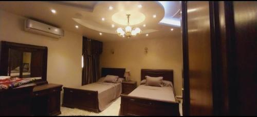 um quarto com 2 camas e um espelho grande em شقة فيو نيلي no Cairo