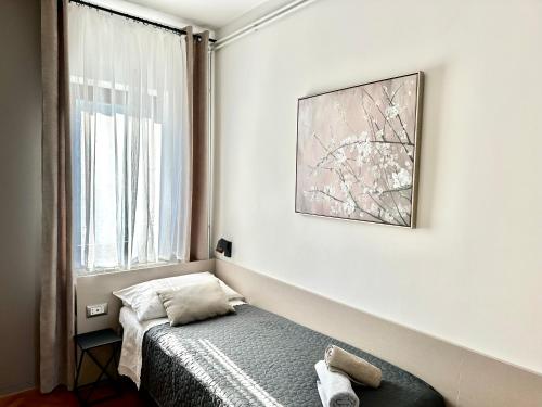 a small bedroom with a bed and a window at Apartments Villa Ida in Opatija