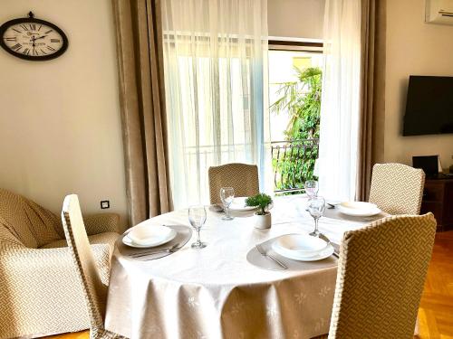 einen Esstisch mit einem weißen Tischtuch und Stühlen in der Unterkunft Apartments Villa Ida in Opatija