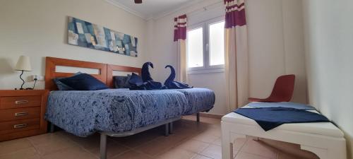 1 dormitorio con 1 cama con edredón azul y silla en Casa Rebecca, apartment with a poolview, en Murcia
