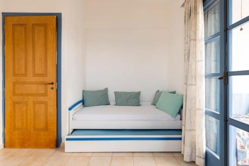 a white couch sitting in a room next to a door at Nefeli's House in Souvala
