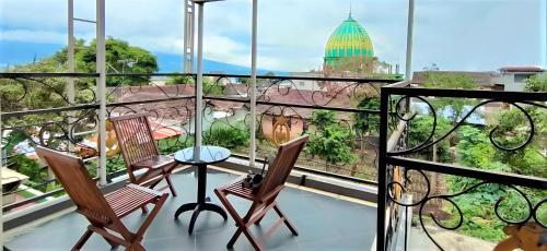 a balcony with two chairs and a table with a view at Omahomy villa di Batu - Full House in Batu
