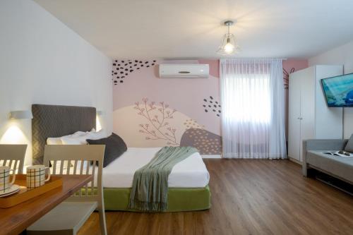 um pequeno quarto com uma cama e uma mesa de jantar em Travel Hotel Eilon em Elon