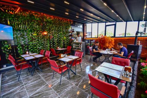 a restaurant with red chairs and a green wall at LOCA Suit LİFE AİRPORT HOTEL in Istanbul