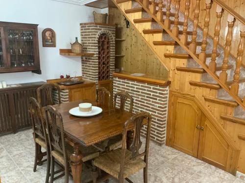 een eetkamer met een houten tafel en een trap bij Casa Hermi in Arenas de San Pedro
