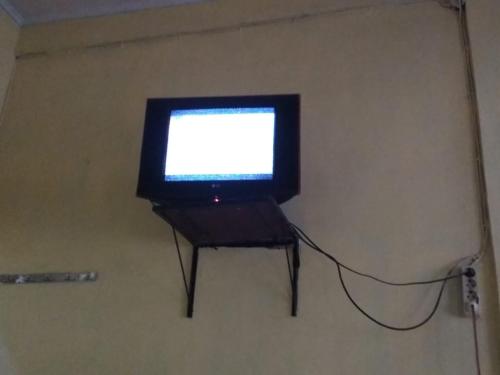 un televisor en un stand en una habitación en Home Sweet Dewi en Kualasimpang