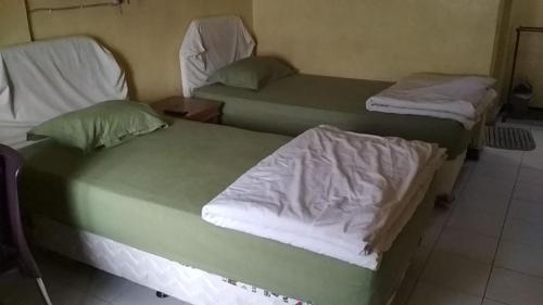 Habitación con 2 camas individuales en Home Sweet Dewi en Kualasimpang