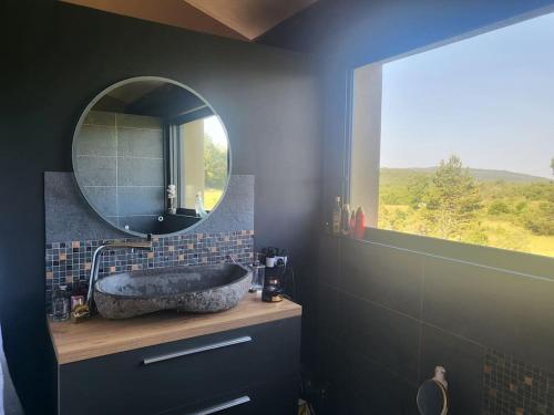 索村的住宿－Coin de paradis en Provence，一间带大型石质水槽和镜子的浴室