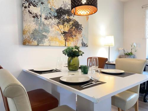 a dining room with a white table and chairs at Moderne helle Ferienwohnung in Remagen
