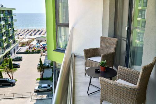a balcony with chairs and a table with a view of the ocean at Silverbay - Indoor Pool & Spa Resort in Mamaia Nord