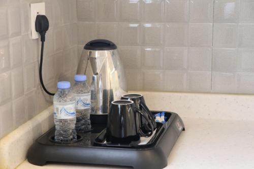 - Hervidor de té y botellas de agua en la encimera de la cocina en قمم بارك Qimam Park Hotel 2, en Abha