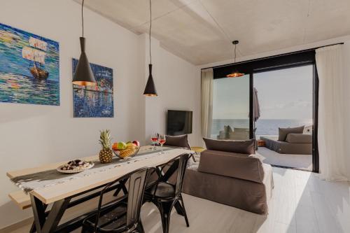 a living room with a dining table and a view of the ocean at Villa Varco in Paleros