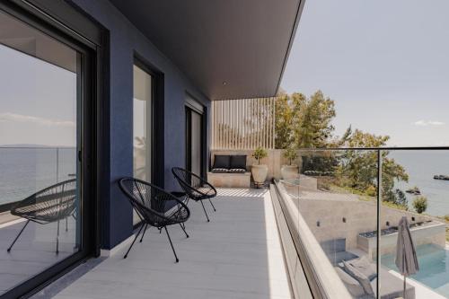 a balcony with chairs and a view of the water at Villa Varco in Paleros