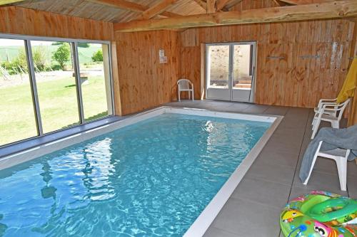 - une grande piscine dans une maison dotée de fenêtres dans l'établissement Grande maison de vacances Les Reinettes, à Cheffois